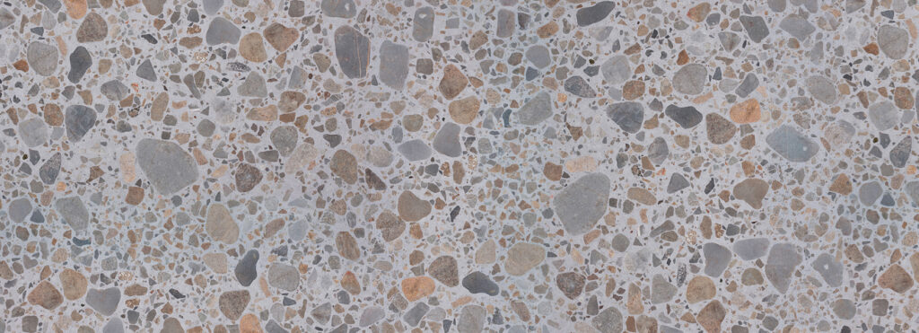 Terrazzo floor with irregular gray, beige, and brown stone chips embedded in light cement.