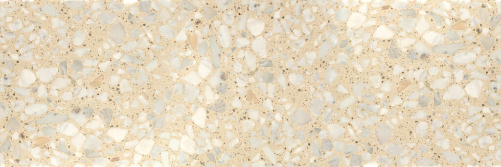 Light beige terrazzo floor with irregular white and gray stone chips, close-up