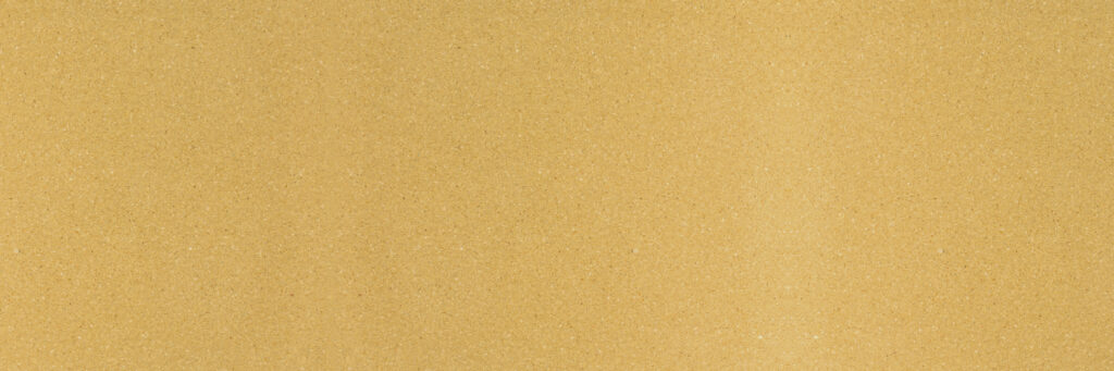 Close-up of fine beige sand texture with small grains scattered evenly across the surface