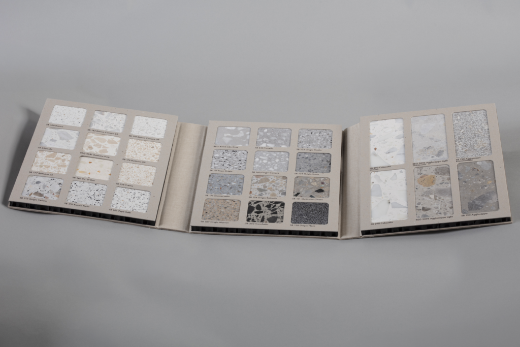 Open color/material sample book with small tile swatches arranged in rows on two opened pages.